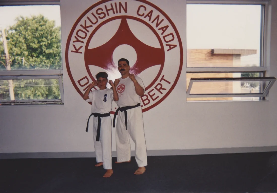 Alexandre Haché y Sensei Jacques Latreille en el dojo, frente al emblema de Kyokushin Canada