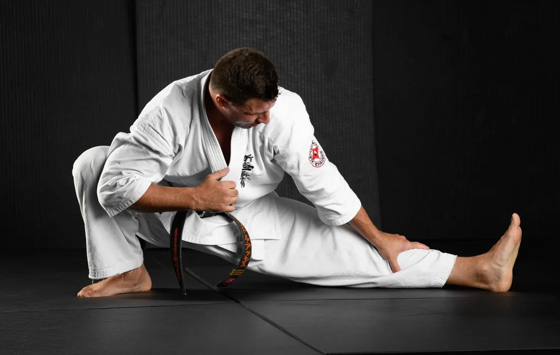 Sensei Alexandre Haché en étirement, au sol, au dojo