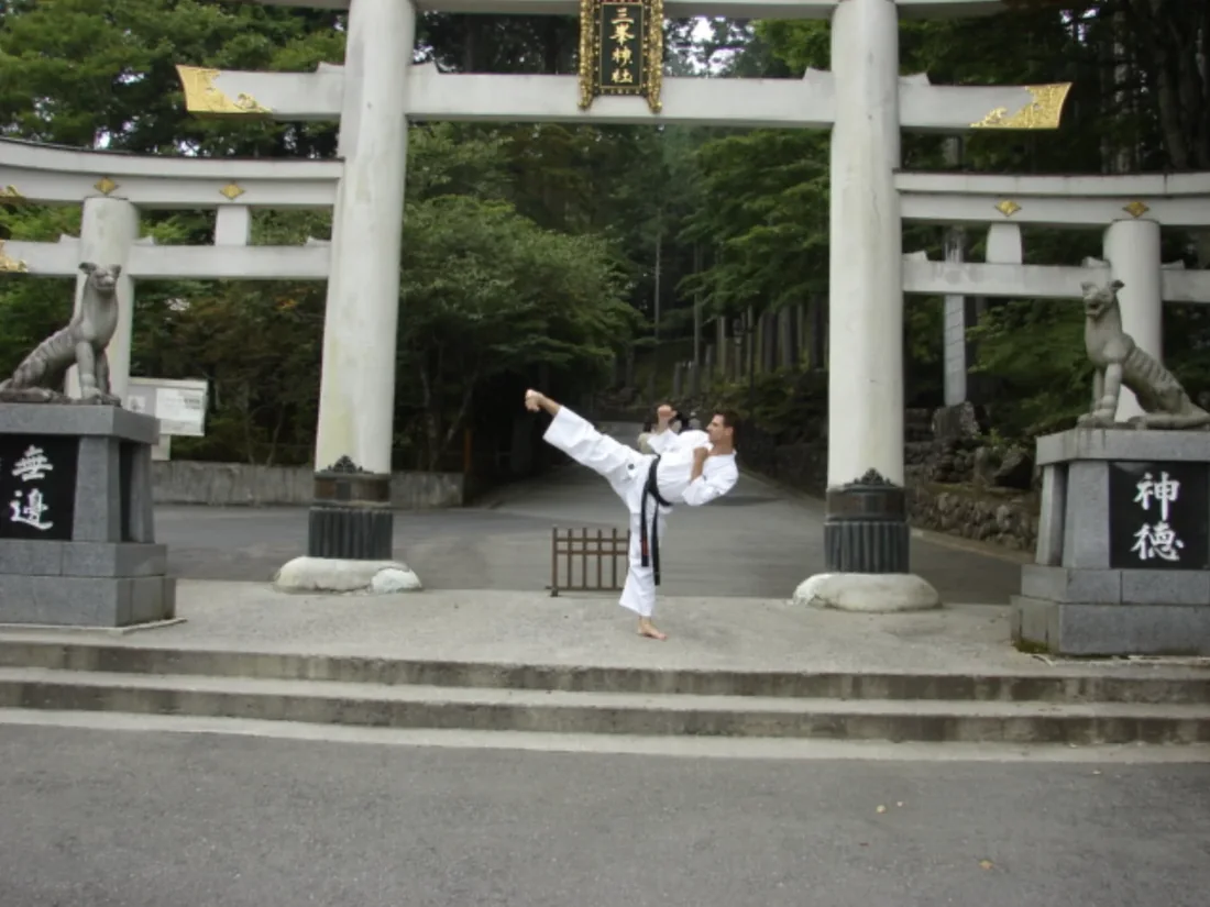 Sensei Alexandre Haché, patada alta frente a un torii en Japón