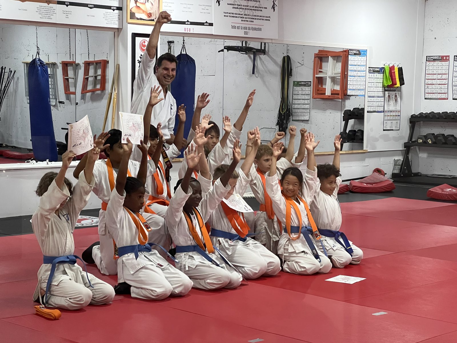 Enfants célébrant leur nouvelle ceinture avec le sensei